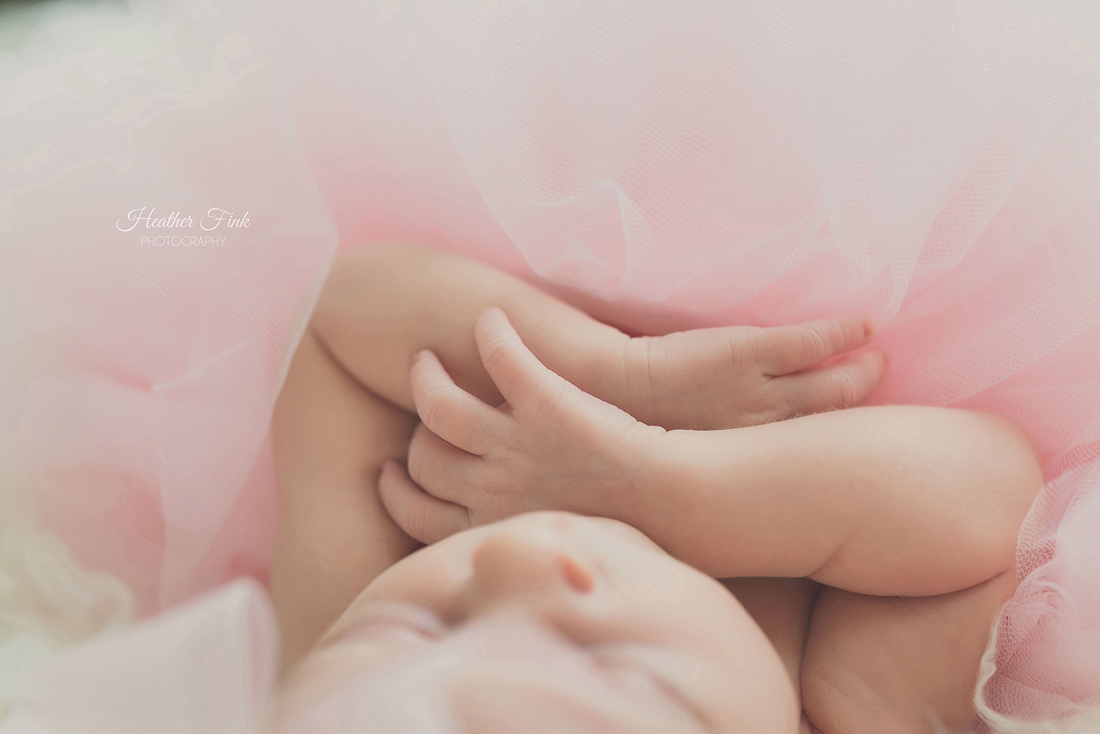 baby girls arms folding around pretty pink tutu