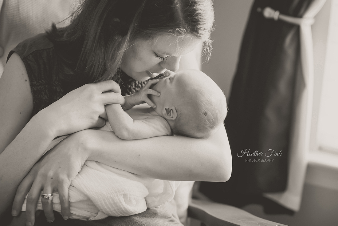 mom snuggling on newborn baby boy during at home session