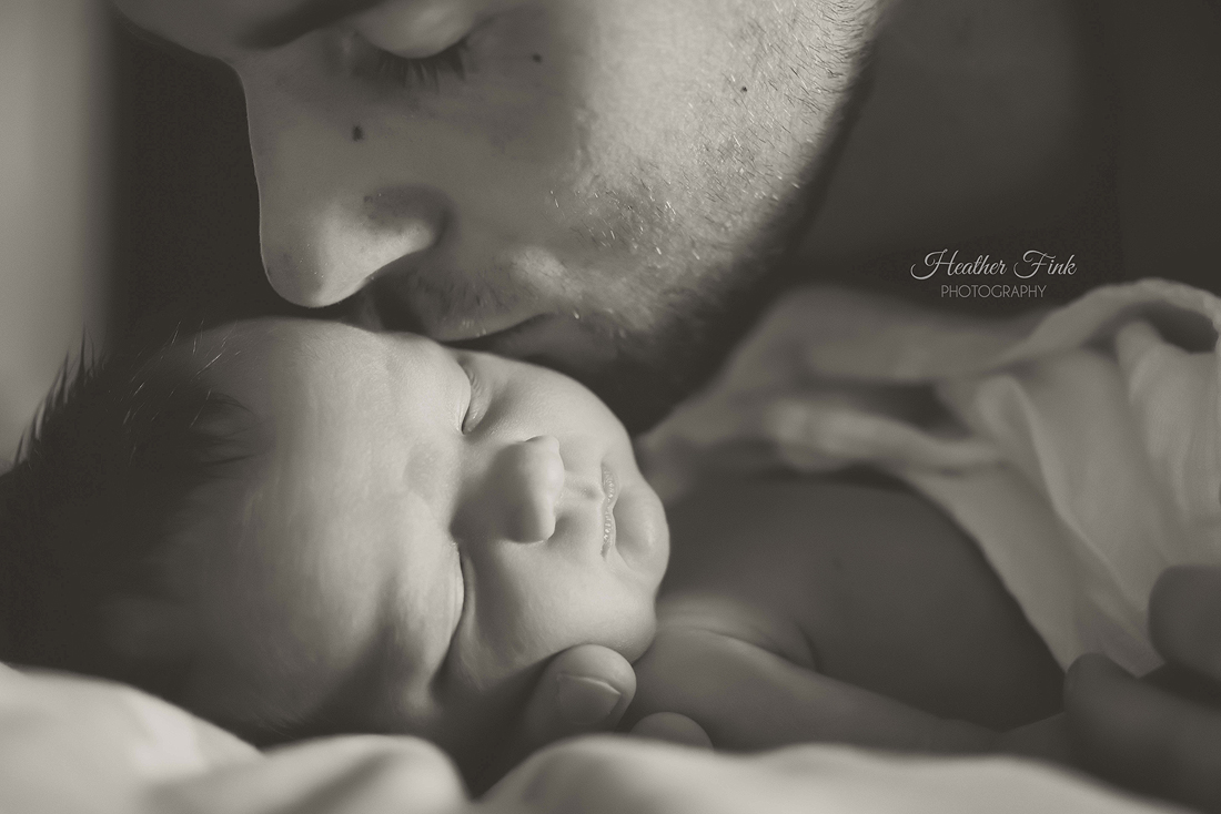 sweet kisses from daddy on newborn baby girl