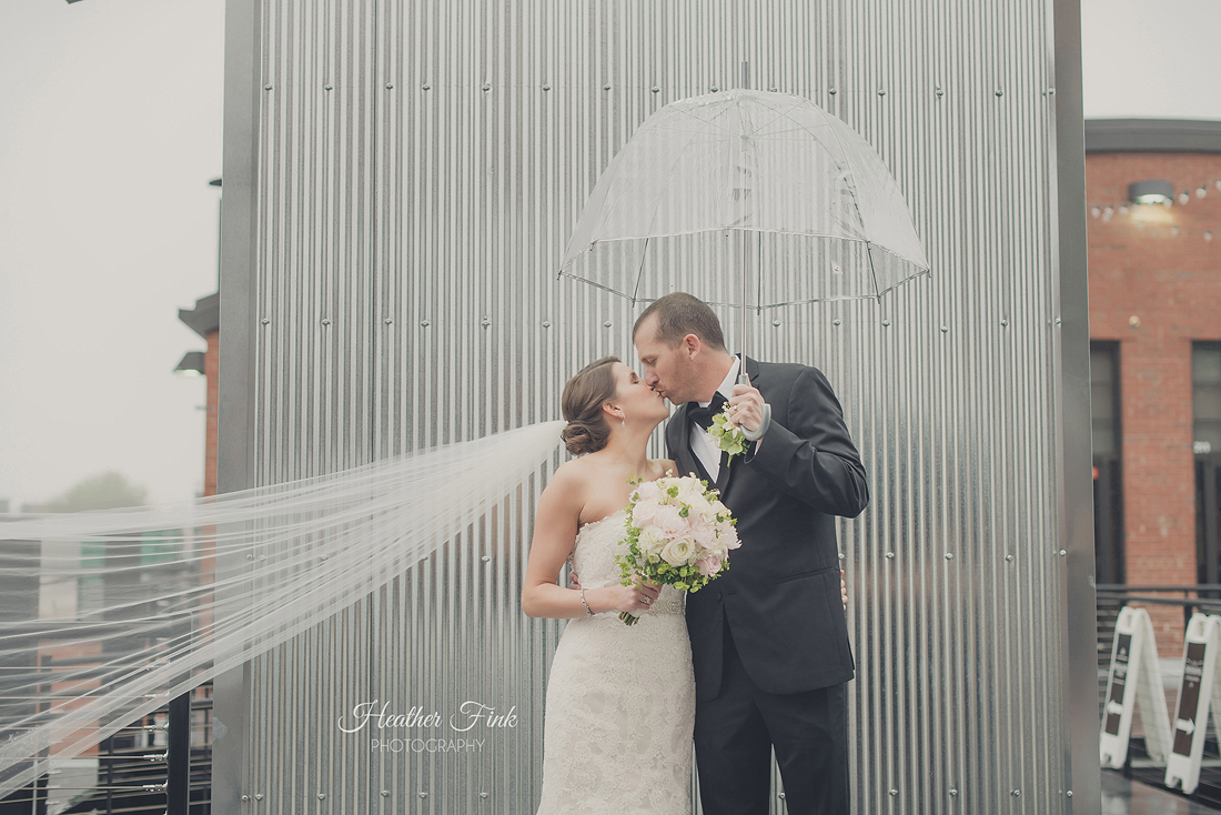 wedding couple kissing in the rain